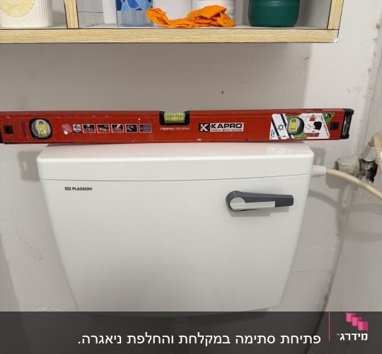 מדף עם חומרי ניקוי ומפלס מים מעל ניאגרה